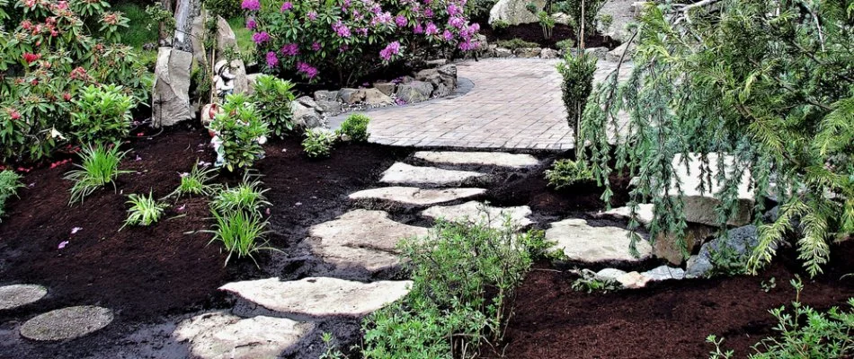 Landscape bed in Delaware, OH, with black mulch, flowers, and plants.